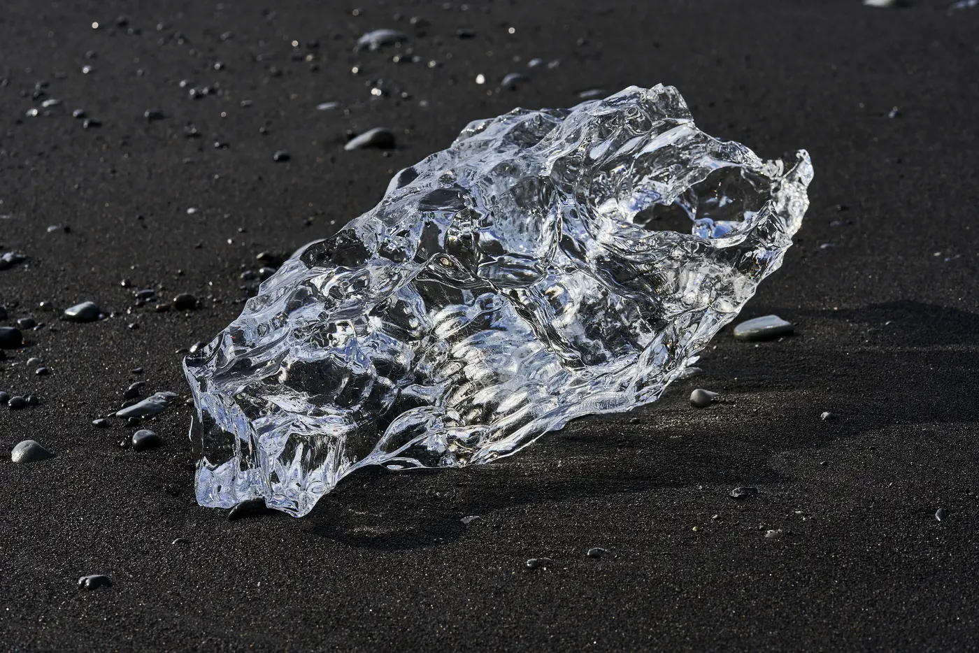 Clear fragments of ice on black sand