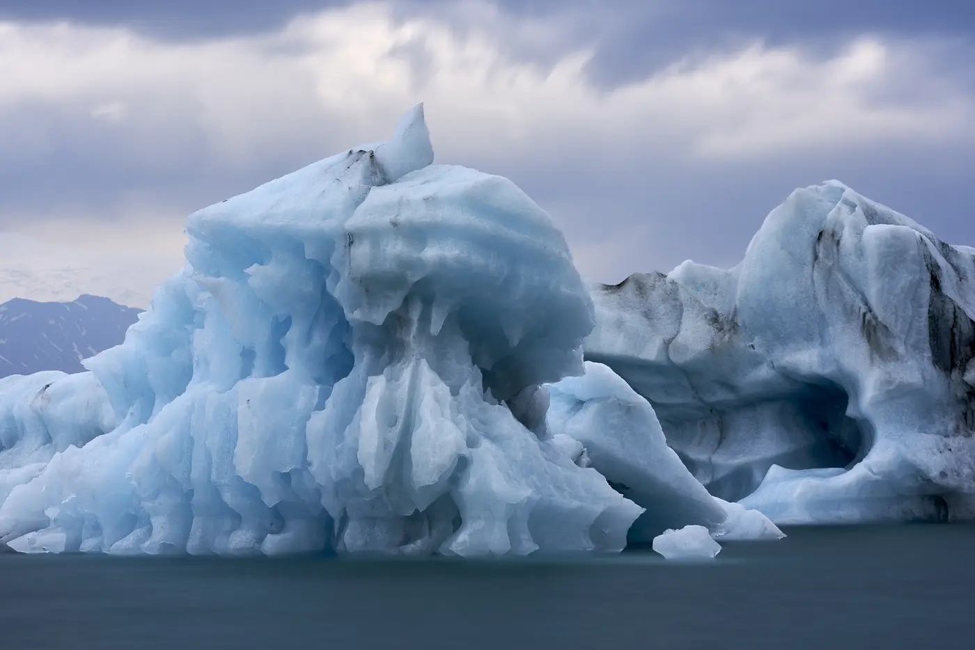 Blue ice drifting on dark water