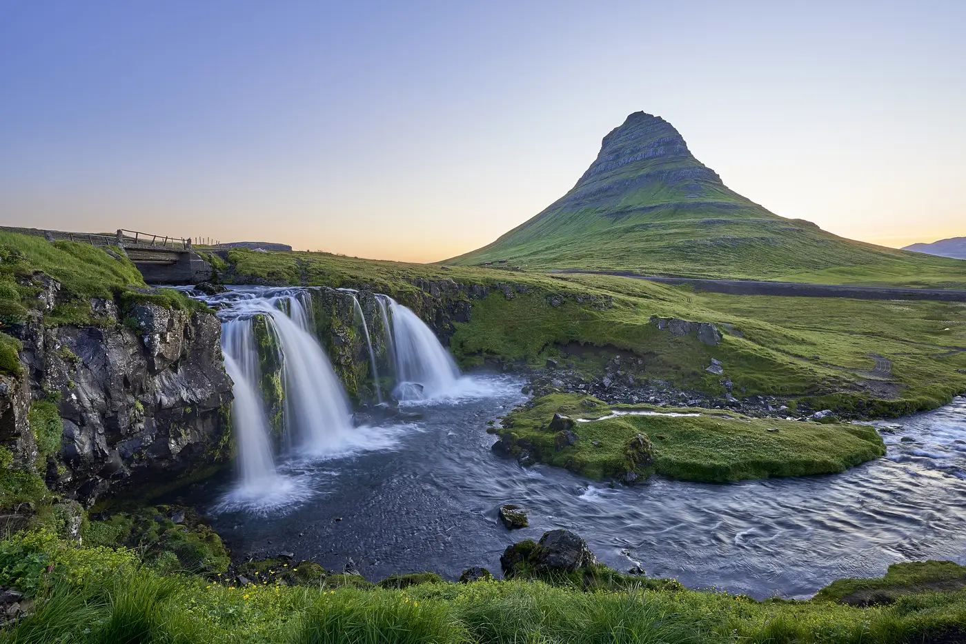 Mount Kirkjufell behind a stepped waterfall