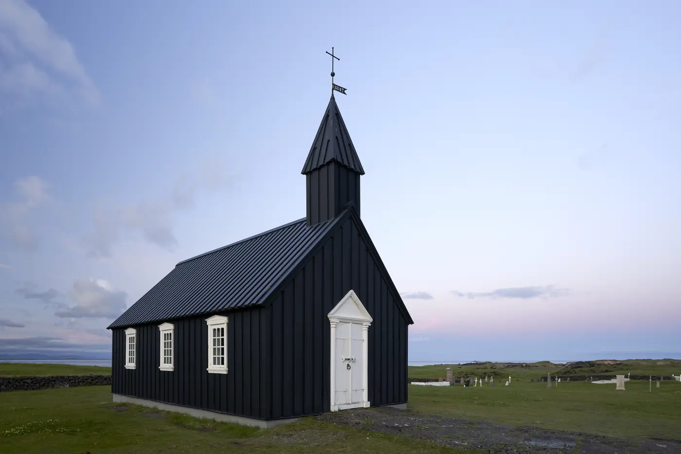 A black timber church under a dramatic sky