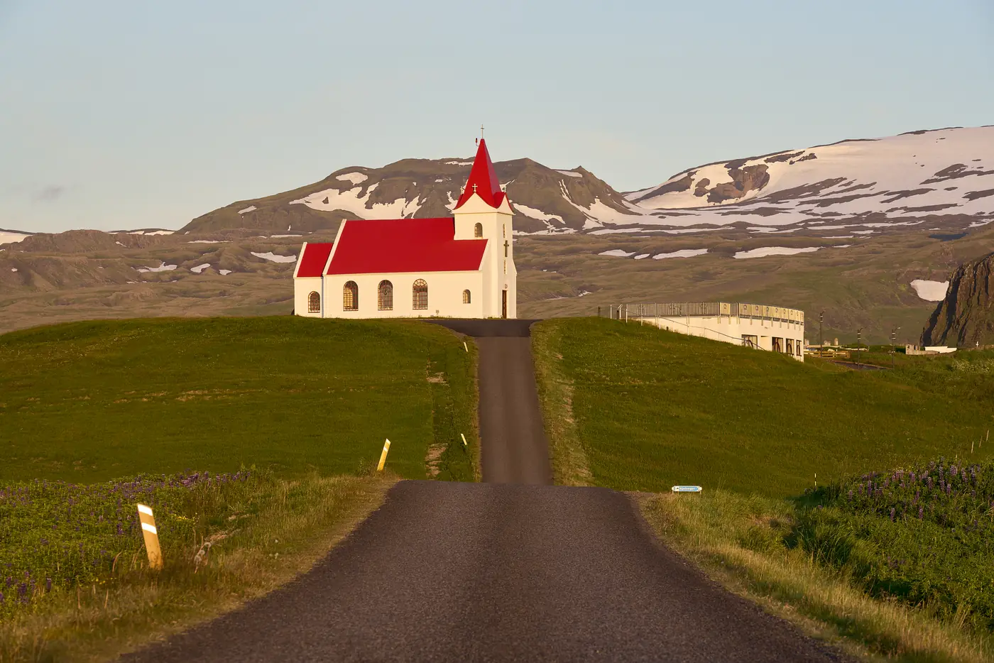 An empty road through green land