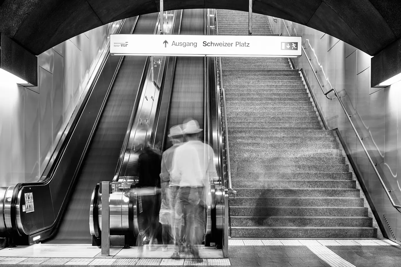 An escalator in a station, black and white