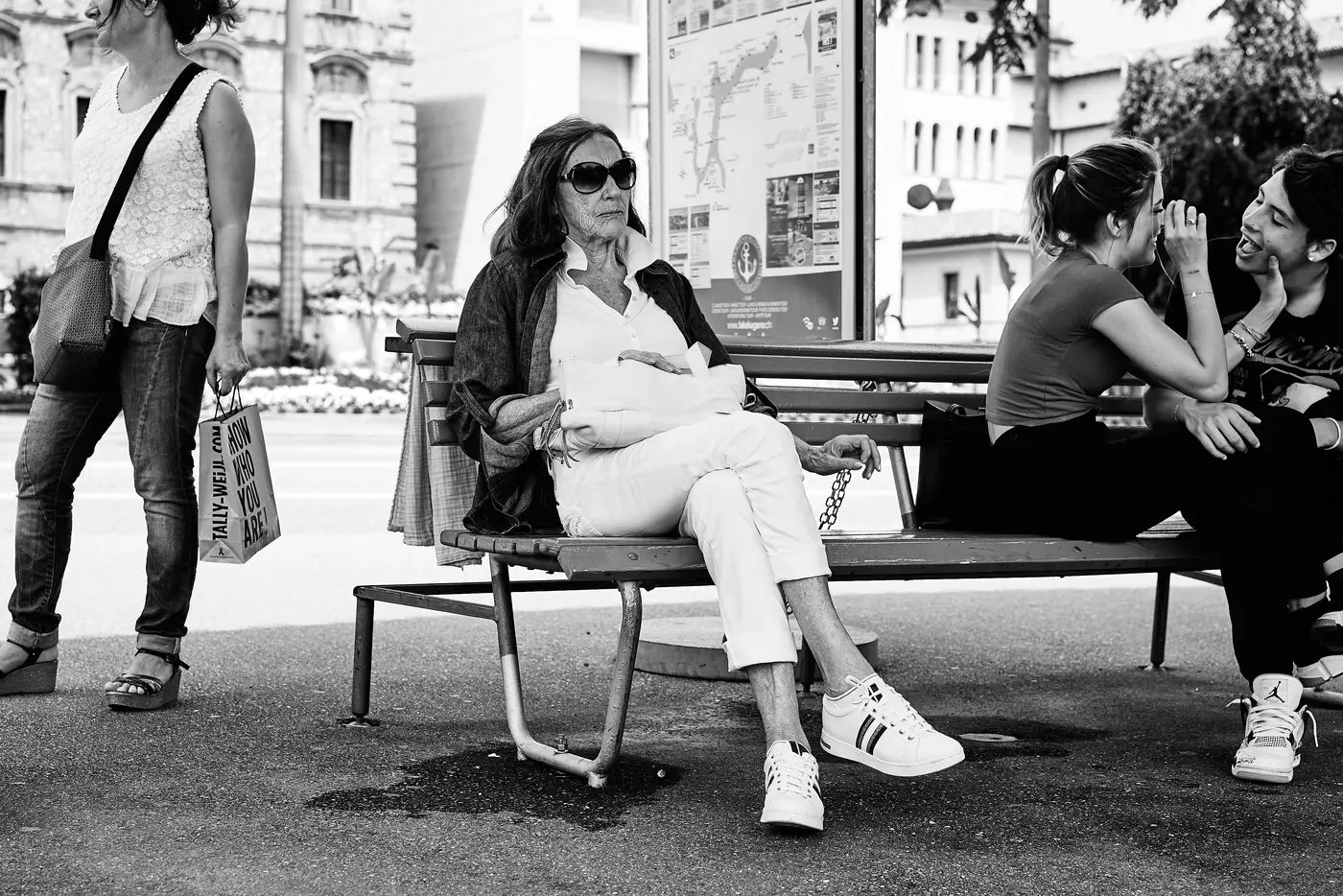 A street scene with people on a bench